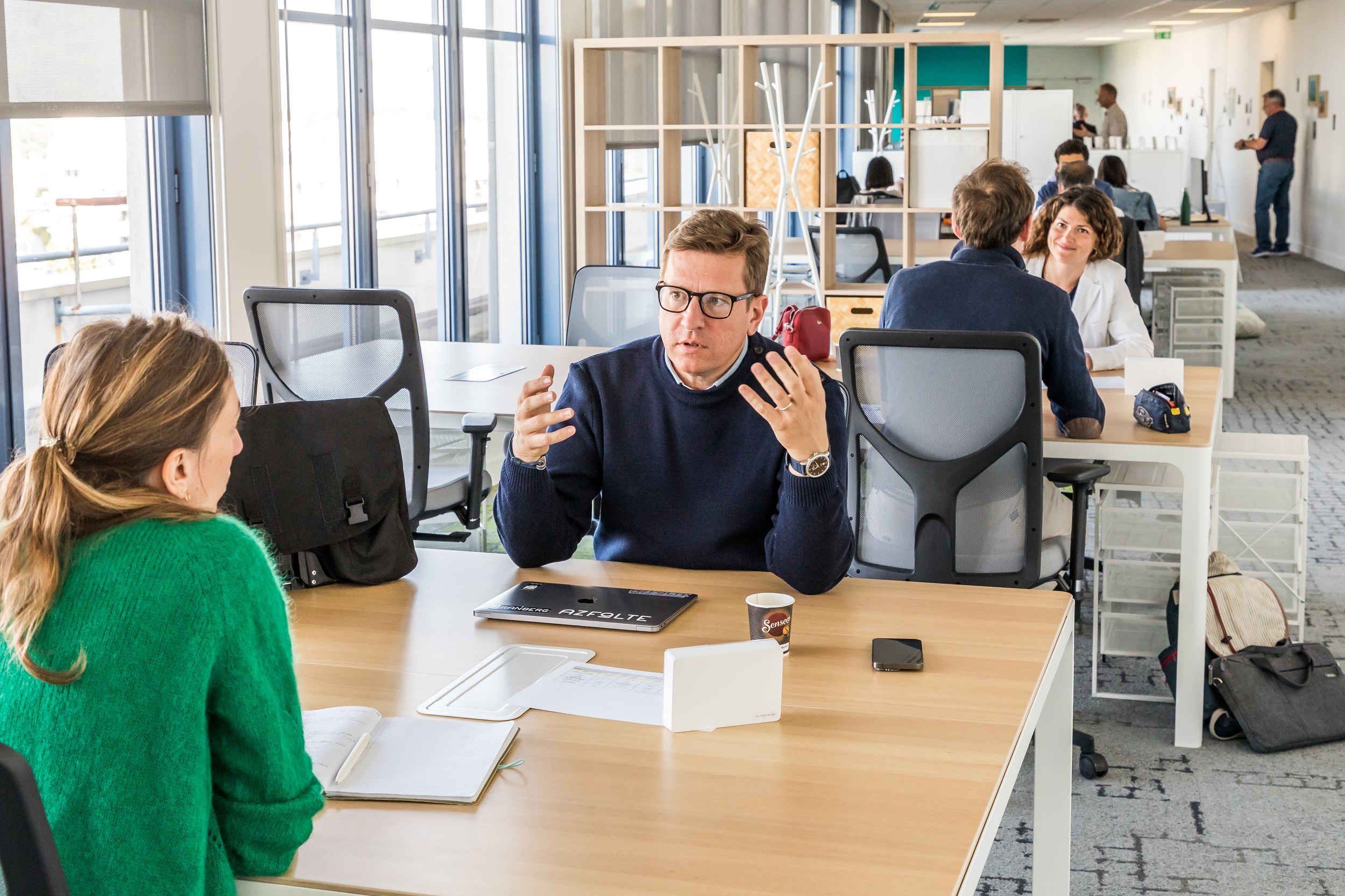 Une personne assise qui discute et fait des gestes de main